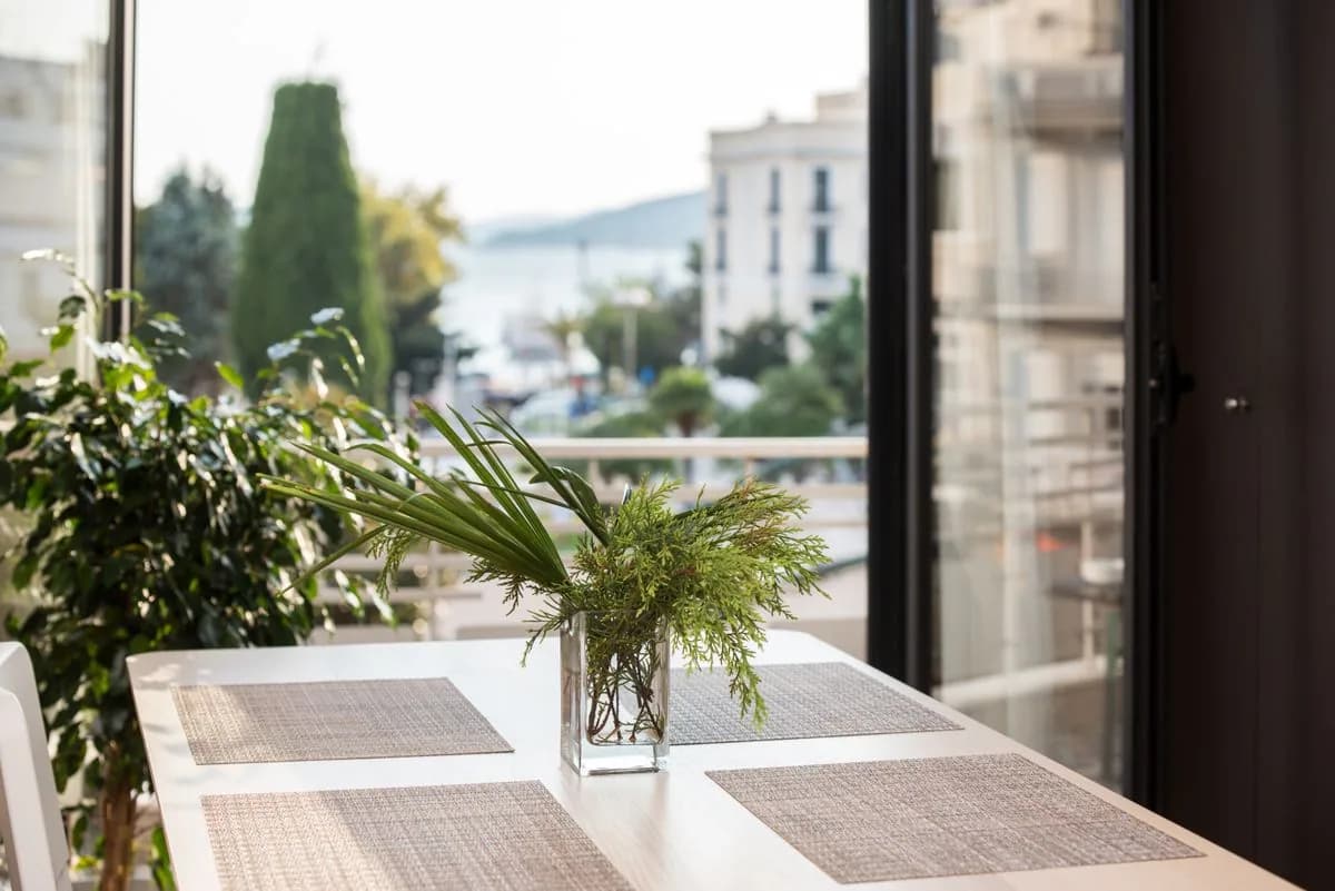 Comedor luminoso con vegetación y una vista urbana